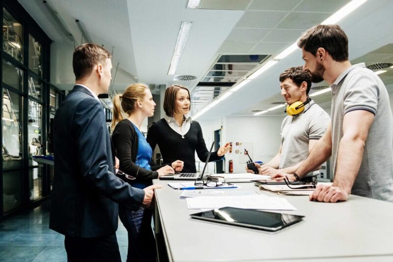 Ihmisiä suunnittelupöydän ääressä, kuvituskuva.