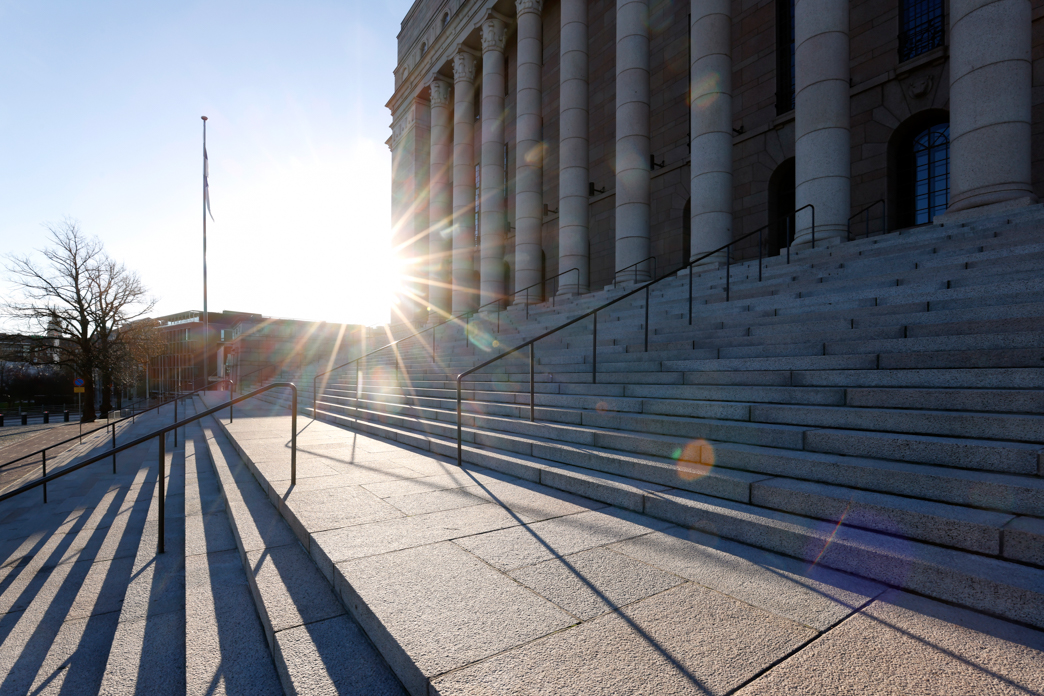 Eduskuntatalo aurinkoisella säällä kuvattuna.