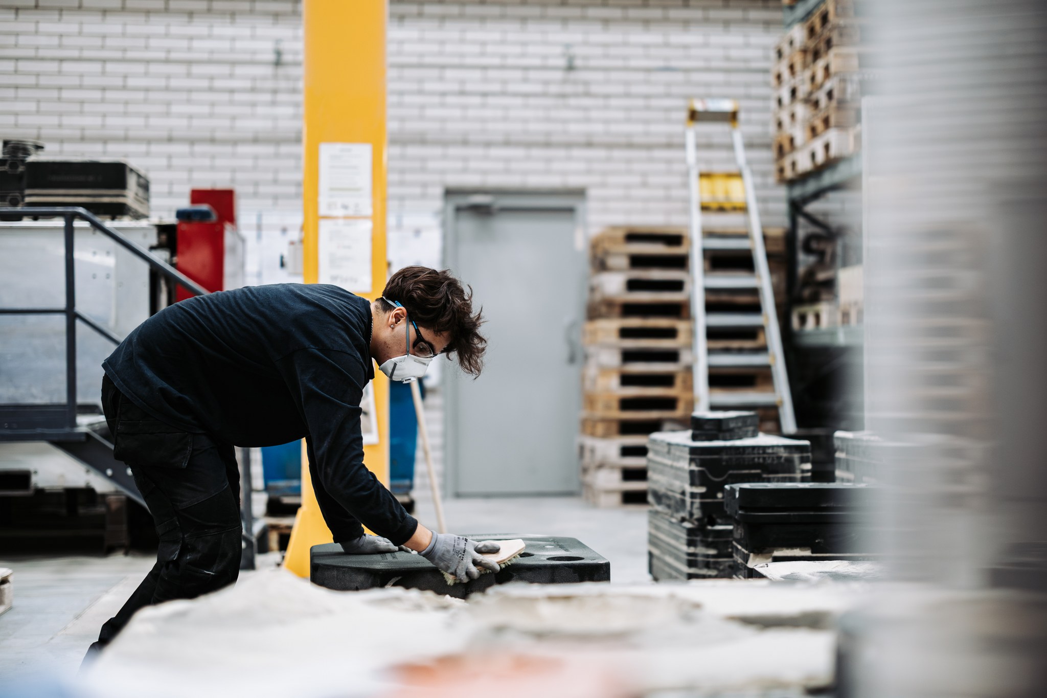 Henkilö työskentelee tehtaassa, kuvituskuva.