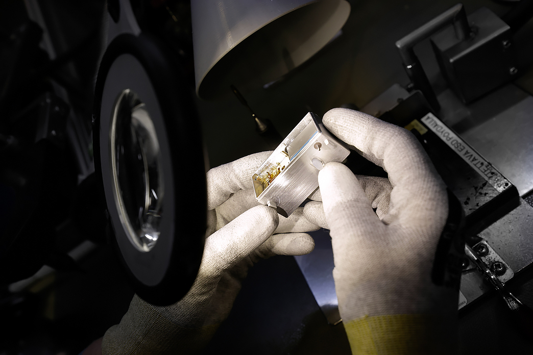 Kädet pitelevät metallista osaa, kuvituskuva.