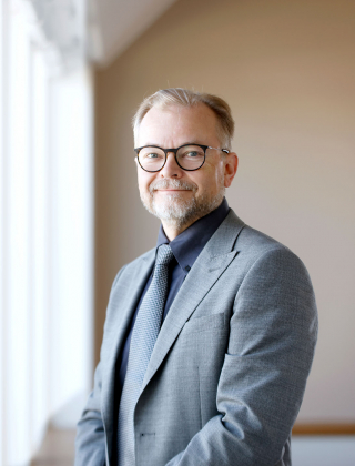 Teknologiateollisuuden johtaja Erkki Ahola hymyilee harmaa puku päällä