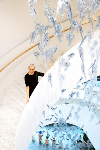 Fiskarin vastuullisuusjohtaja Kati Ihamäki seisoo lasisaksista tehdyn taideteoksen taustalla.