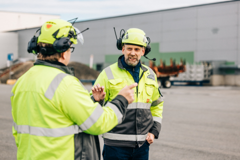 Mäkelä Alun toimitusjohtaja toimitusjohtaja Marko Orpana ja hallituksen puheenjohtaja Petri Mäkelä seisovat kypärät päässä tehdasrakennuksen edessä ja keskustelevat.