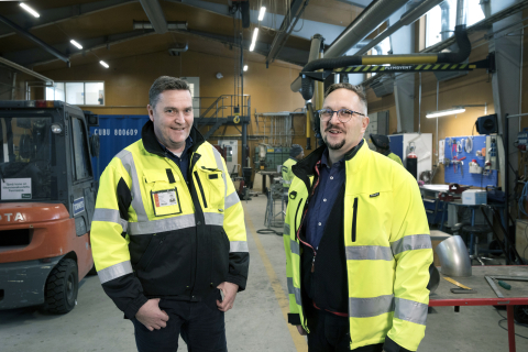 Tormets Oy:n toimitusjohtaja Kari Rantamaa ja operatiivinen johtaja Antti Valta seisovat esivalmistushallissa keltaiset työtakit päällä.