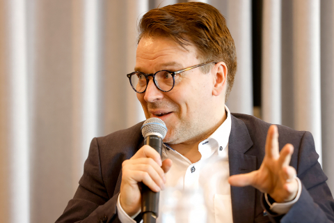 Eurovaaliehdokas Ville Niinistö puhuu mikrofoniin ja elehtii vasemmalla kädellään.