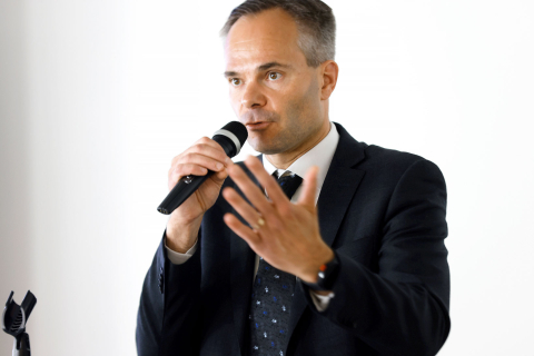 Ympäristö- ja ilmastoministeri Kai Mykkänen puhuu mikrofoniin lähikuvassa.