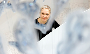 Fiskarin vastuullisuusjohtaja Kati Ihamäki hymyilee saksista tehdyn taideteoksen taustalla.