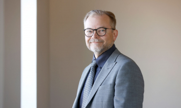 Teknologiateollisuuden johtaja Erkki Ahola hymyilee harmaa puku päällä