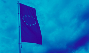 EU-lippu siniseksi värjätyssä kuvassa, taustalla pilvinen taivas