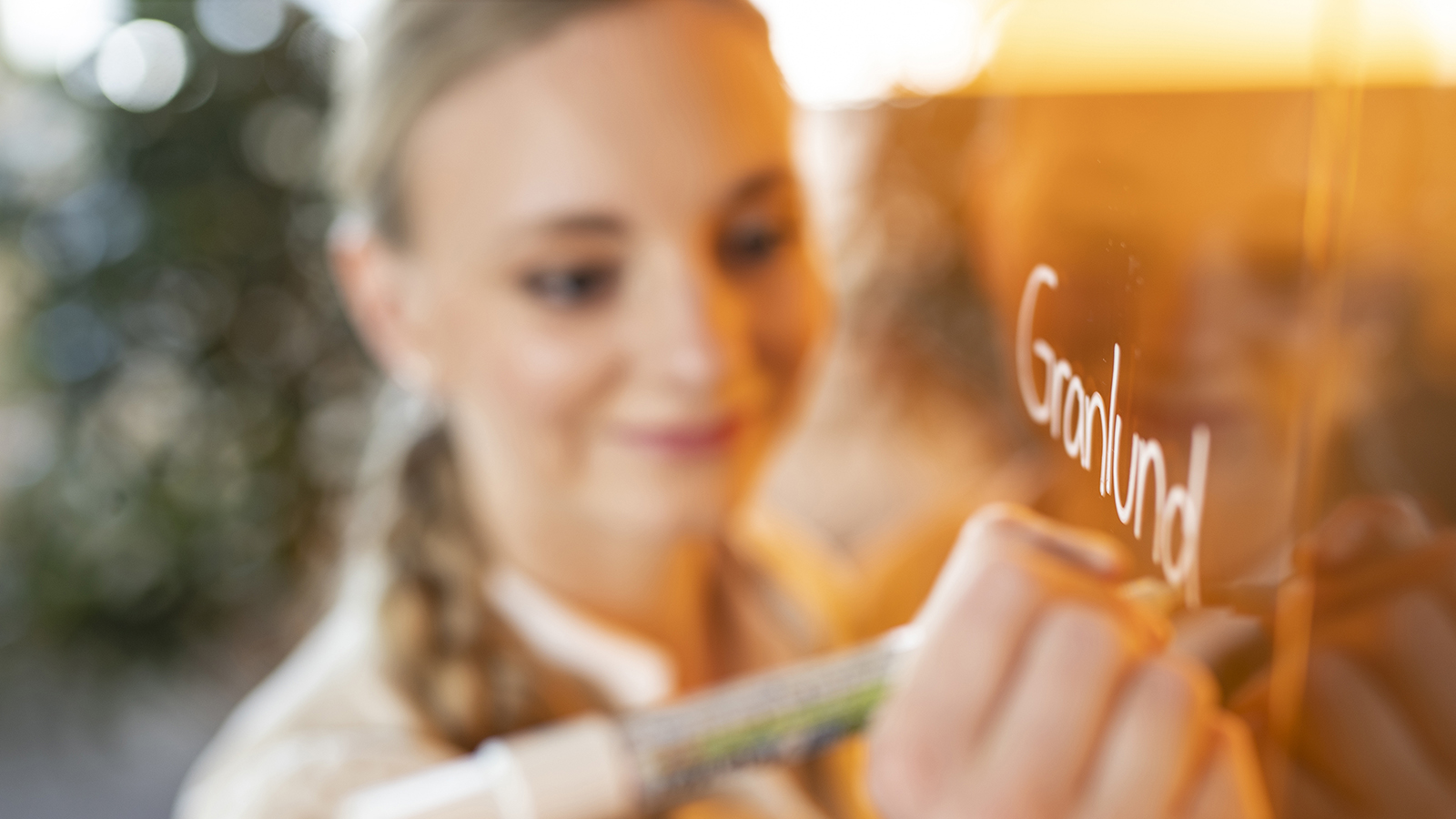 hymyilevä nainen kirjoittaa taululle "Granlund"