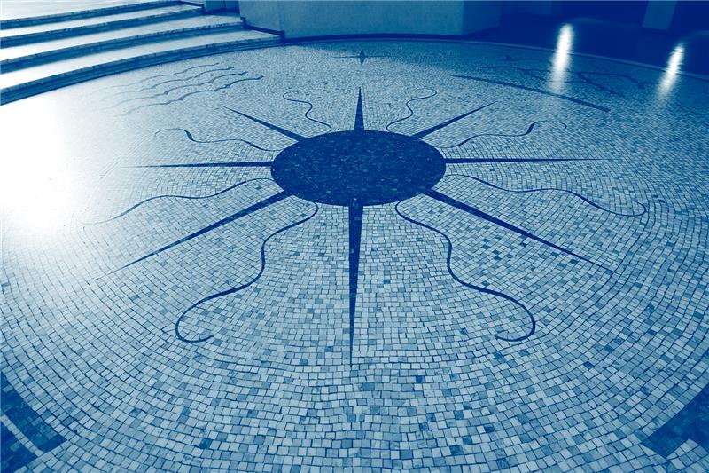 Yksityiskohta eduskuntatalosta, mosaiikkilattiaan rakennettu kompassi, siniseksi sävytetty kuva