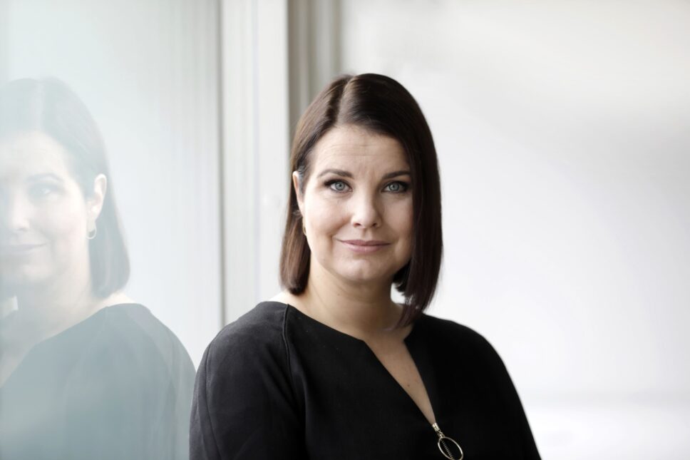 Nainen katsoo kameraan.