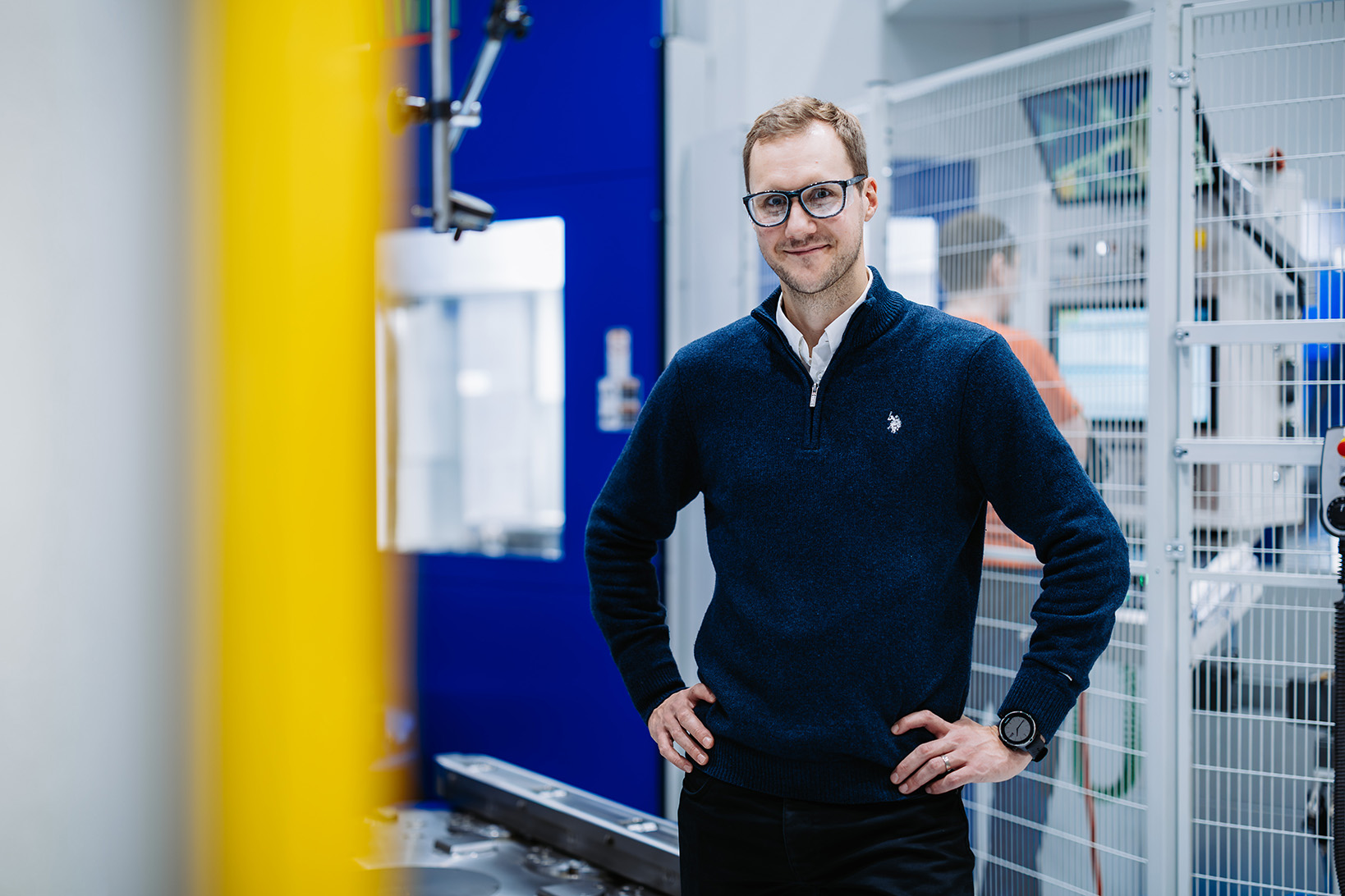 Silmälasipäinen mies katsoo kameraan.