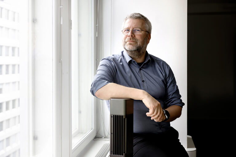 Mies istuu ikkunalaudalla