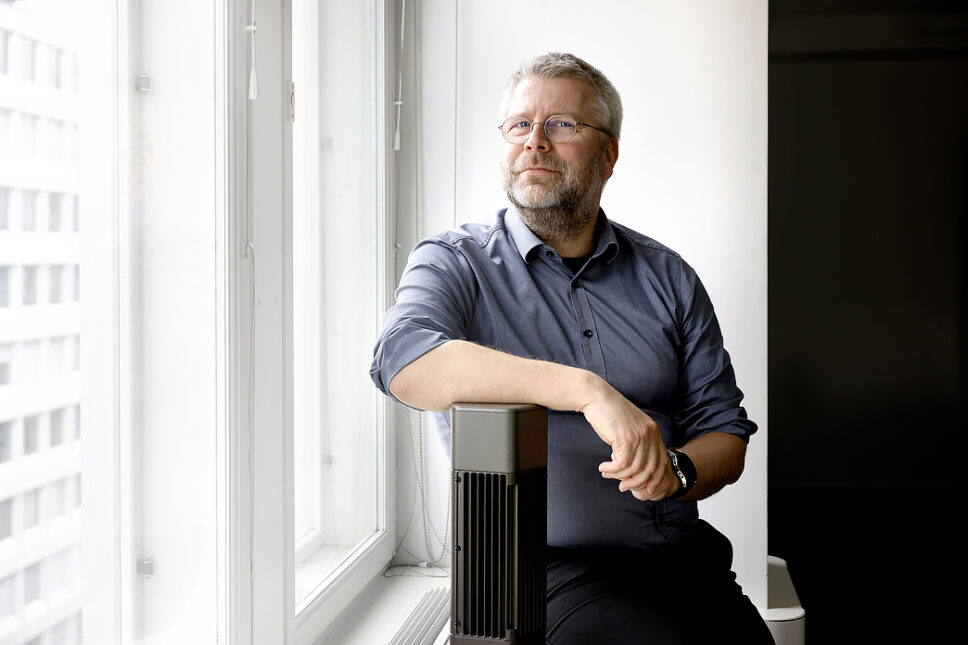 Mies istuu ikkunalaudalla