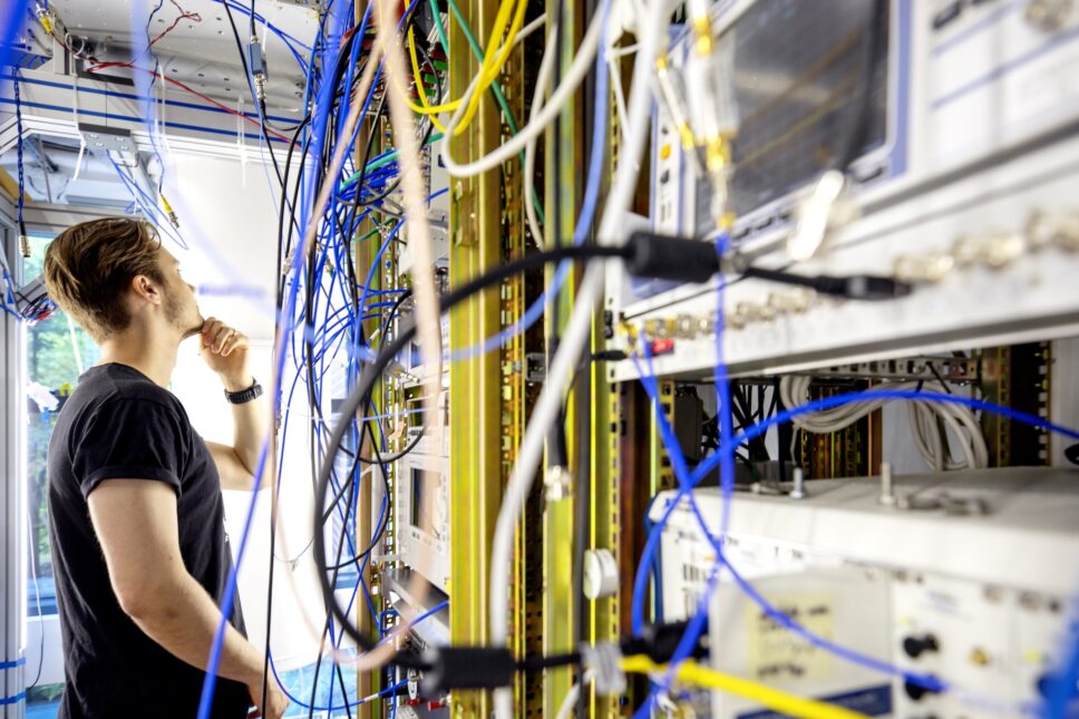 Henkilö katso pohtien erivärisiä johtoja.