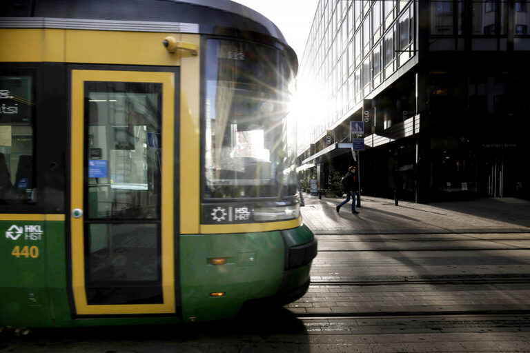 Raitiovanun etuosa, taustalla olevasta rakennukssta heijastuu kirkas aurinko